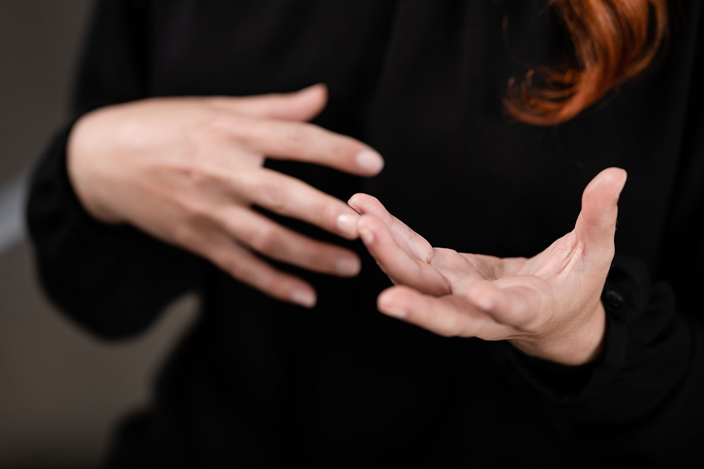 Close-up photograph of a white woman's expressive hands