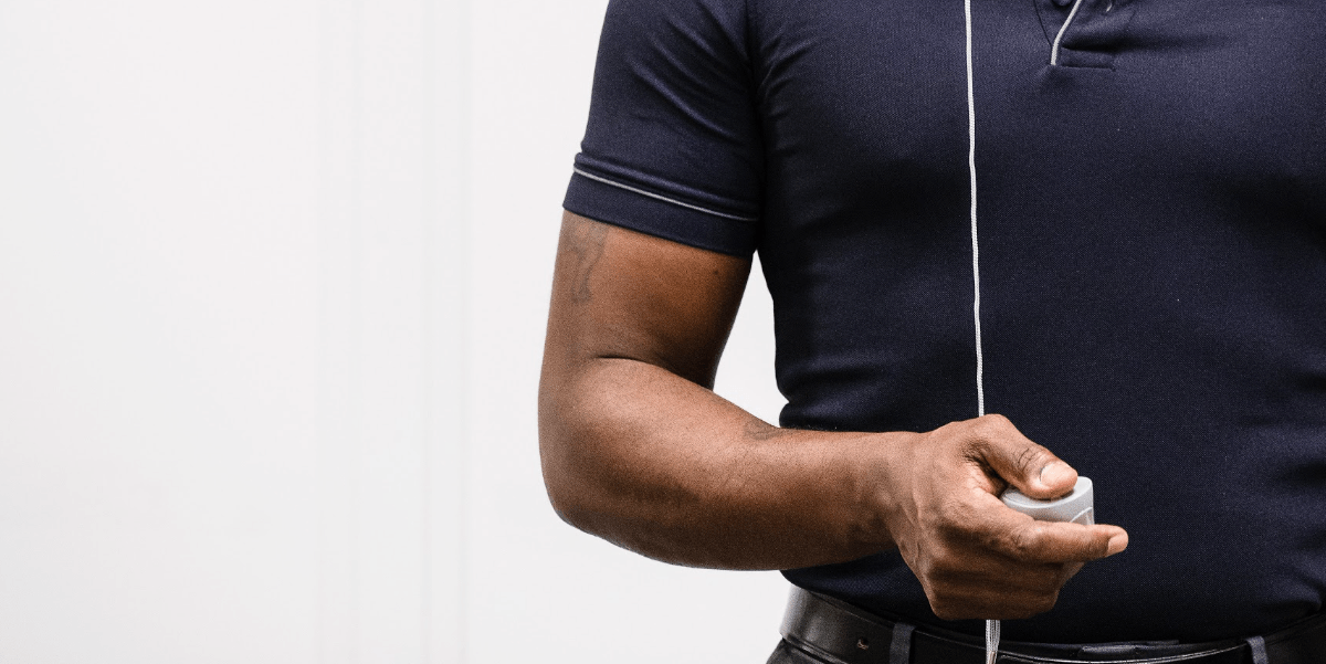 Black man wearing a navy polo shirt holding a VR handset