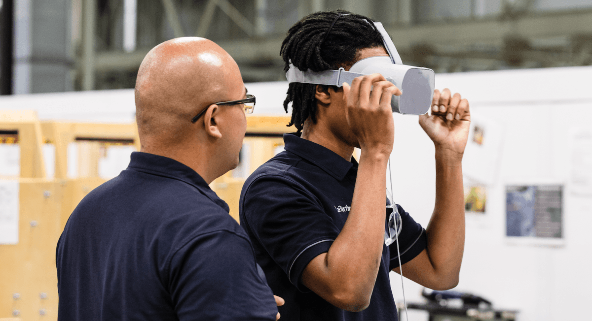 One male coaching another male wearing a Strivr VR headset